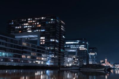 Illuminated buildings against sky at night