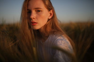 Portrait of beautiful woman on field against sky