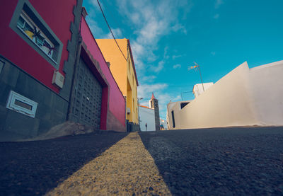 Road amidst buildings in city against sky