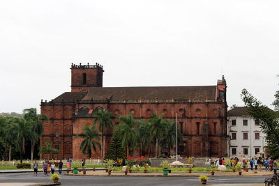 People in front of historical building against clear sky