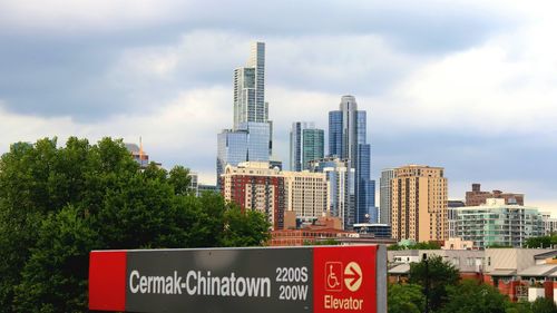 Information sign by buildings against sky in city