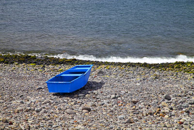 Blue boat on shore at beach