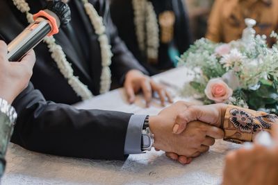 Midsection of couple holding hands