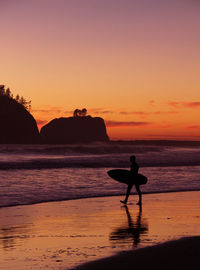 Silhouette of people on beach at sunset