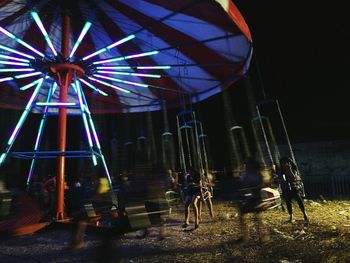 Low angle view of illuminated ferris wheel at night