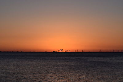 Scenic view of sea against orange sky