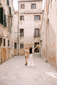 Rear view of couple standing outside building