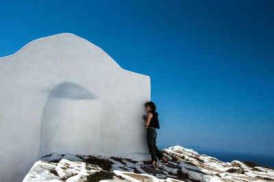 Woman standing against clear blue sky