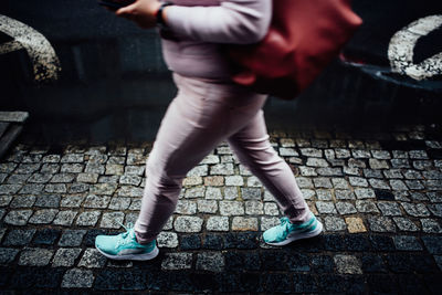 Low section of woman walking on footpath