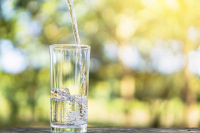 Closeup pouring fresh water on drinking glass