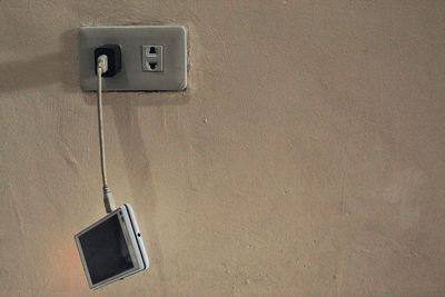 Close-up of telephone booth against wall at home