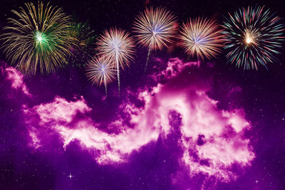 Low angle view of fireworks against sky at night