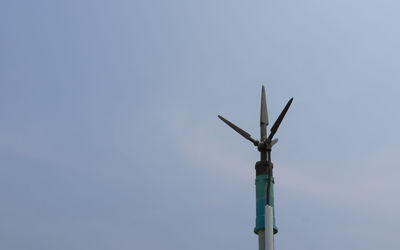 Low angle view of wind turbine against clear blue sky