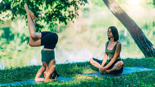 Yoga woman by the water. headstand pose