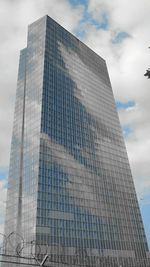 Low angle view of modern building against cloudy sky