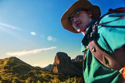 Portrait of young man against mountains against sky