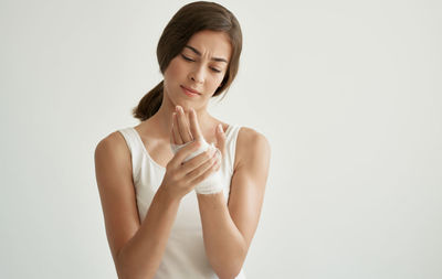 Young woman standing against white background