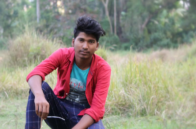 Young man sitting on field