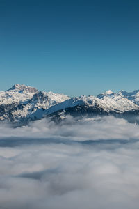 Scenic view of snowcapped mountains against clear blue sky