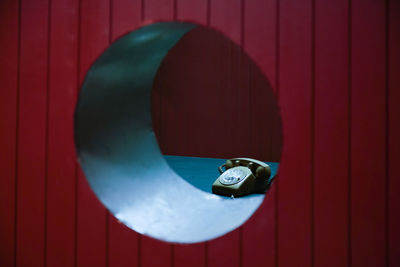 Rotary phone seen through circle on wall in office