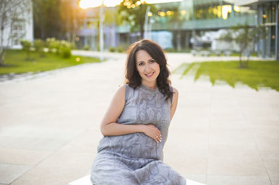 Portrait of smiling young woman sitting outdoors