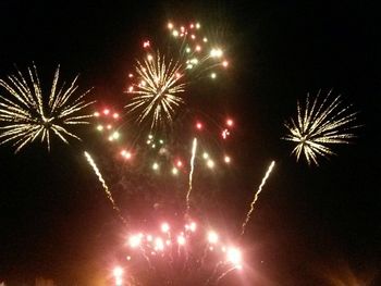 Low angle view of firework display at night