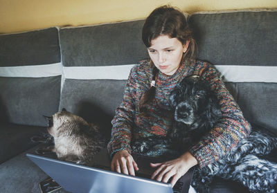 Woman working on laptop by pets at home