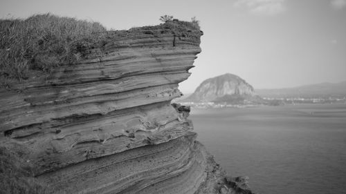 Rock formations on beach against sky