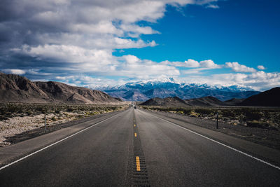 Empty road with mountains in background