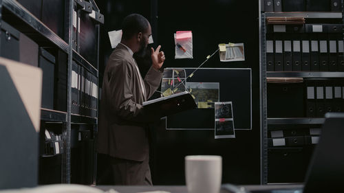 Rear view of man using laptop on table