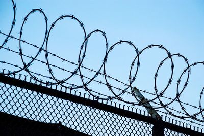 Low angle view of barbed wire against sky