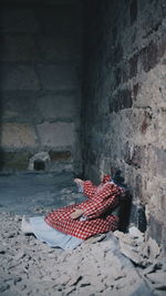 Headless doll by wall at abandoned place