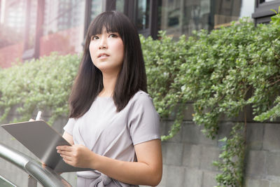 Portrait of young woman using mobile phone outdoors