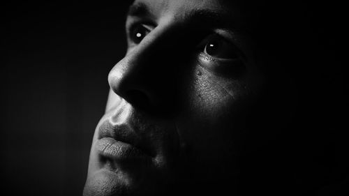 Close-up of a woman over black background