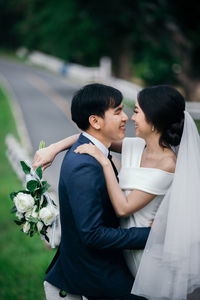 Married couple standing on road in park