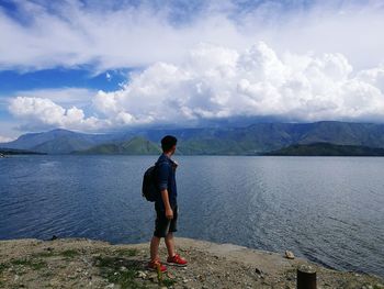 Full length of man standing by lake against sky