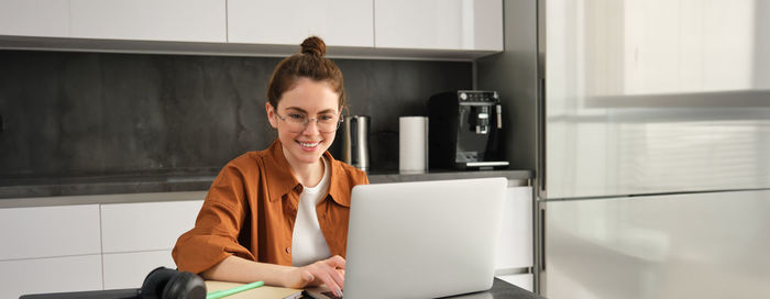 Portrait of young man using mobile phone at home