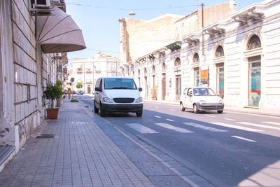 Cars on road amidst buildings in city