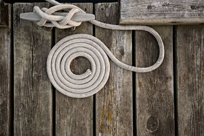 Directly above shot of rope tied up on cleat at pier