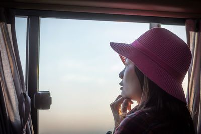 Portrait of woman looking through window