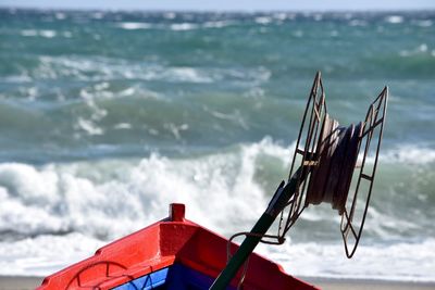 Close-up of rusty fishing road in boat on sea shore