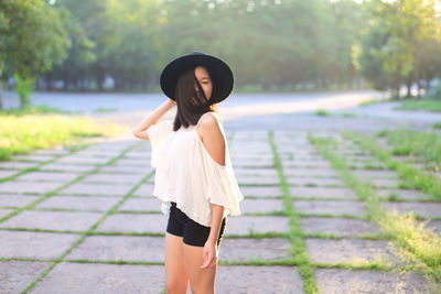 Full length of woman standing on footpath