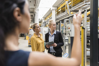 Women with tablet talking in modern factory