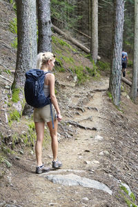 Full length of woman standing in forest