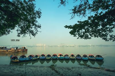 Boats moored in lake against sky