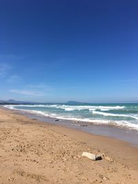 Scenic view of beach against blue sky