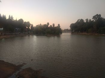 Scenic view of lake against clear sky at sunset