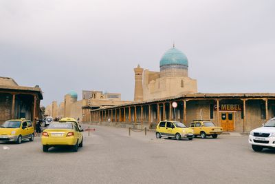 Vehicles on road against buildings in city