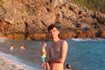 Portrait of shirtless man standing at beach