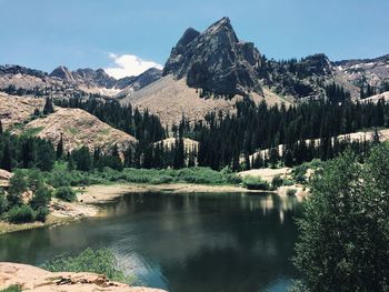 Scenic view of lake and rocky mountains on sunny day